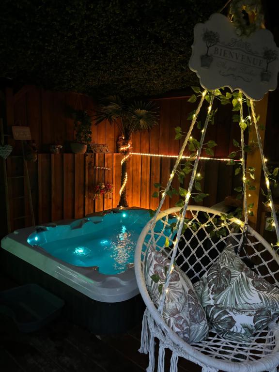 une baignoire dans une cour éclairée dans l'établissement l idylle chalet, à Biscarrosse