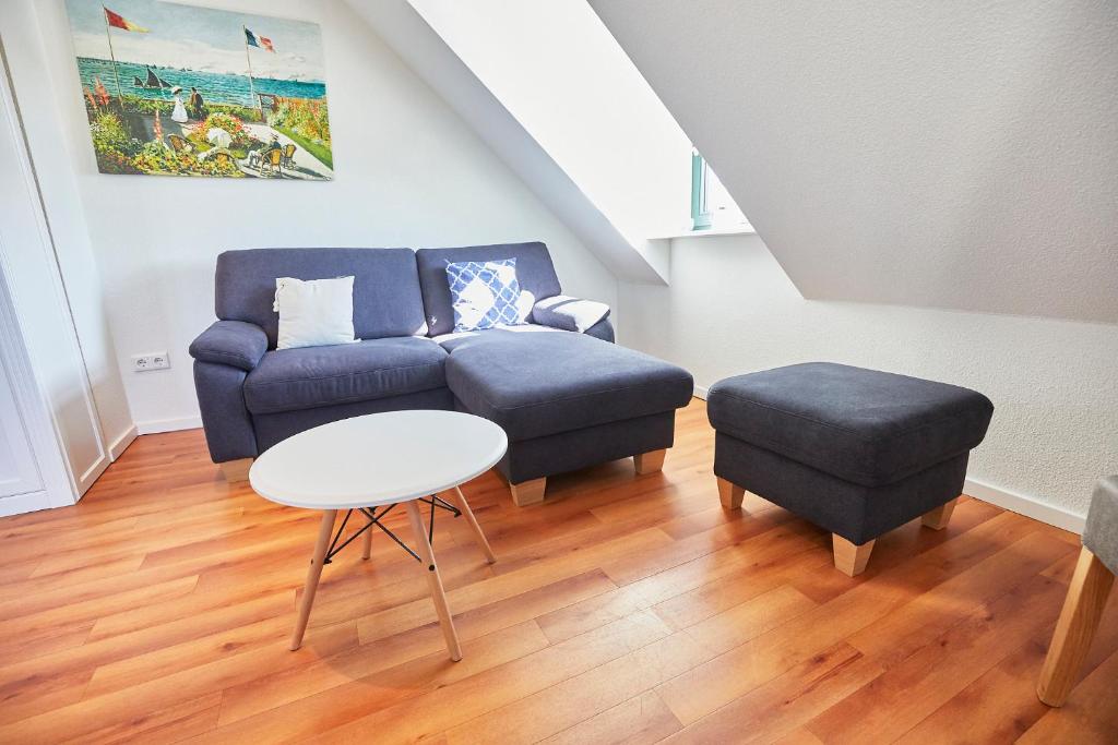 - un salon avec un canapé bleu et un tabouret dans l'établissement "Klein-Wiebke" in der Villa Wilhelmine, à Borkum
