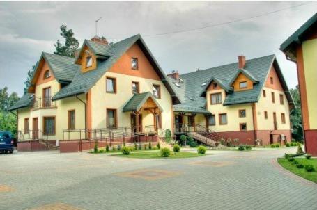 Spacious house with multiple gables, surrounded by paved driveway and greenery.