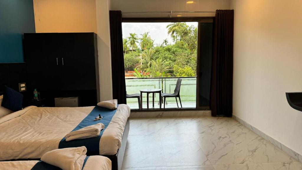 a bedroom with a bed and a view of a balcony at Golden Pearl Resort By Gemstone Hospitality in Alibag