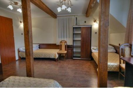 Spacious room with multiple beds, wooden beams, and a wardrobe.