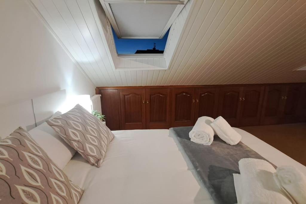 a bedroom with a bed with two towels on it at La Buhardilla de Tuy in Tui