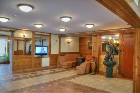 Cozy hotel lobby with wooden decor, seating area, and a television.