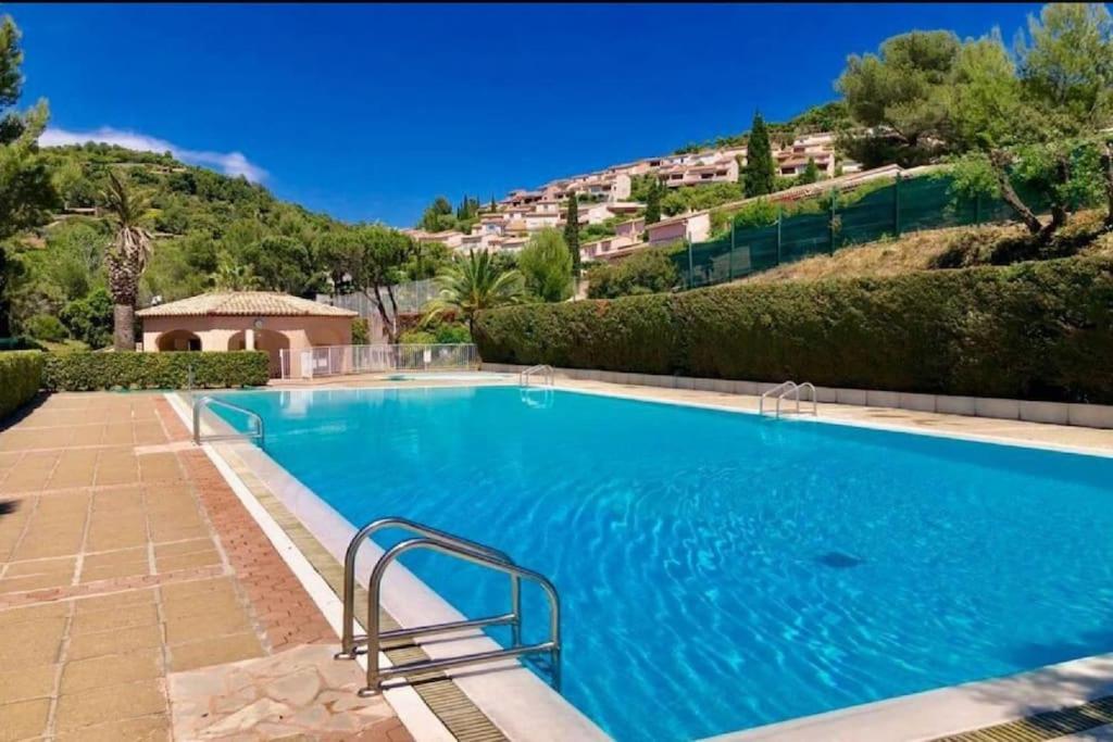 une grande piscine bleue avec une colline en arrière-plan dans l'établissement Appartement vue mer clim 4 personnes résidence boulouris Panorama, à Saint-Raphaël