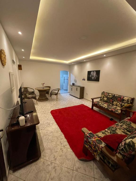 a living room with a couch and a red rug at Recanto dos Cajueiros in Cabo Frio