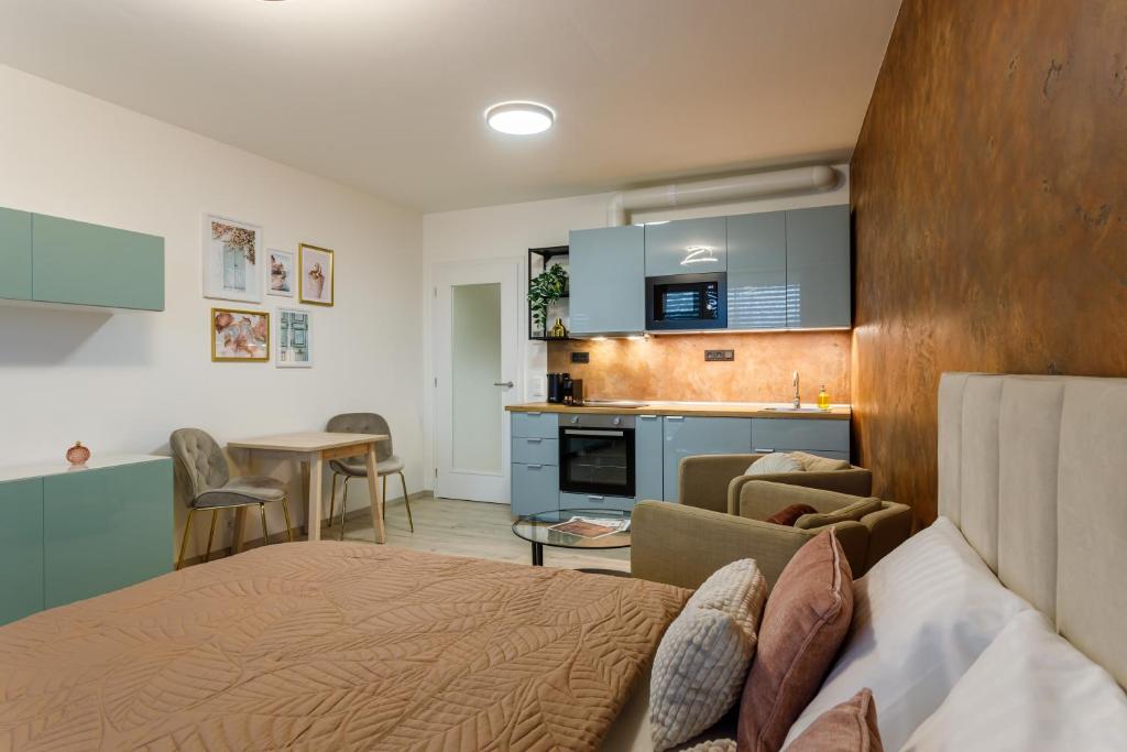 a bedroom with a bed and a kitchen in a room at Terrace View Apartment - Golden Apartments Rezidence Nová Karolina in Moravská Ostrava