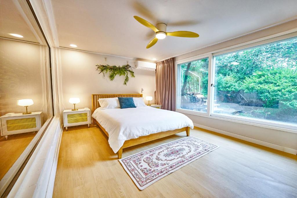 une chambre avec un lit et une grande fenêtre dans l'établissement Jt Tailored Service Home Near Hyehwa Station, à Séoul