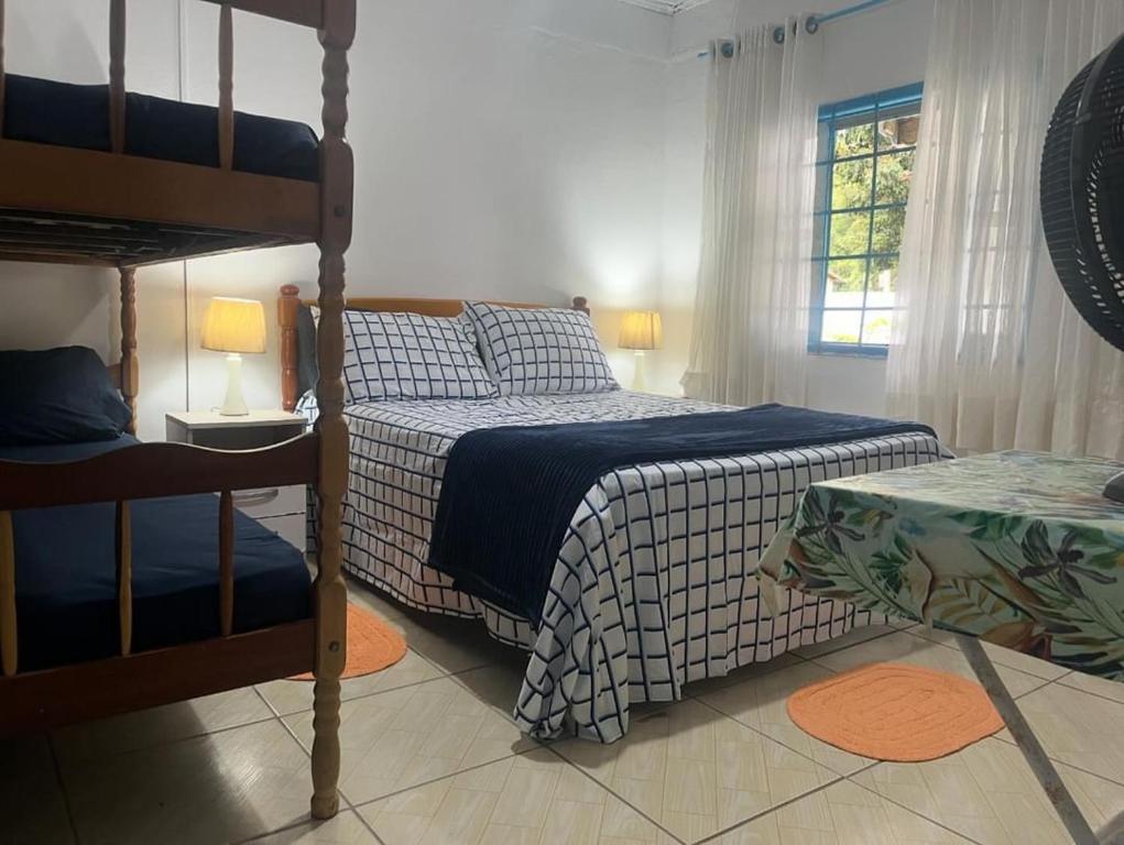een slaapkamer met een bed en een stapelbed bij casa de praia em Itapoá SC a uma quadra da praia in Itapoa
