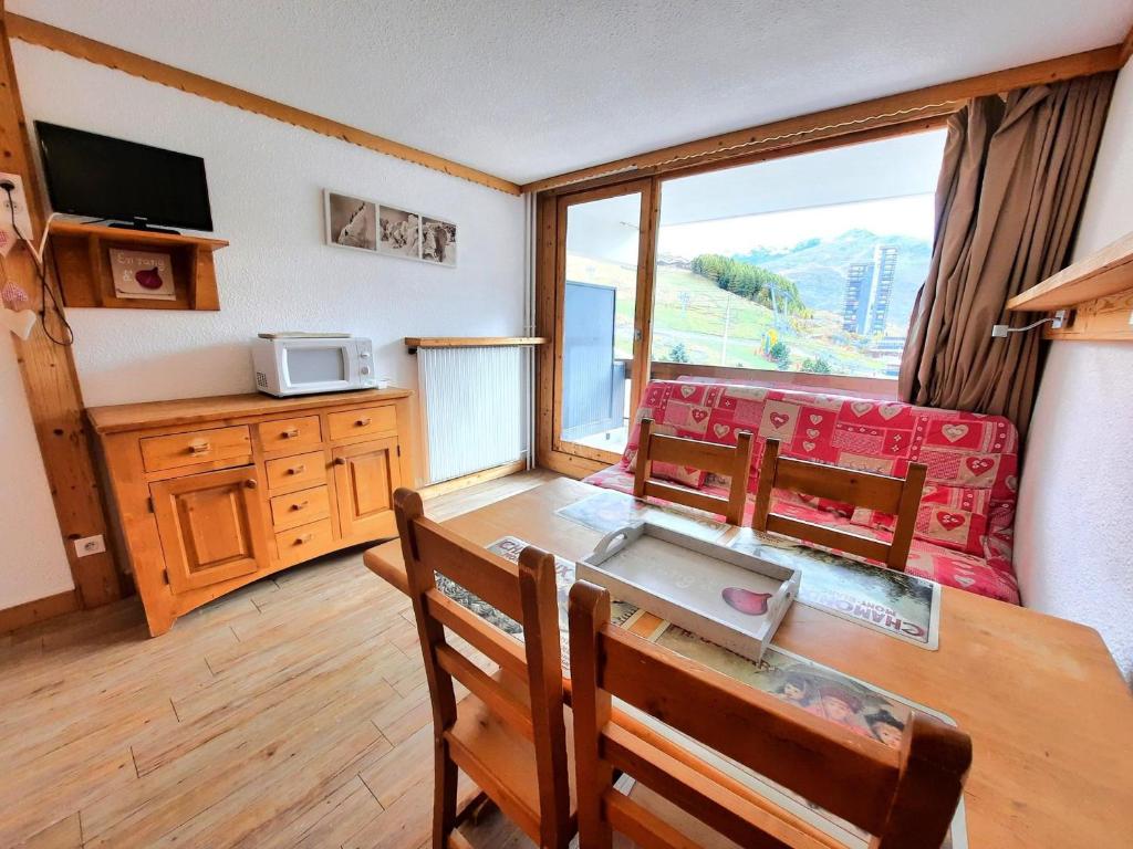 une salle à manger avec une table et des chaises et une fenêtre dans l'établissement Studio au pied des pistes, balcon sud, coeur des Ménuires, 4 pers. - FR-1-452-142, aux Menuires