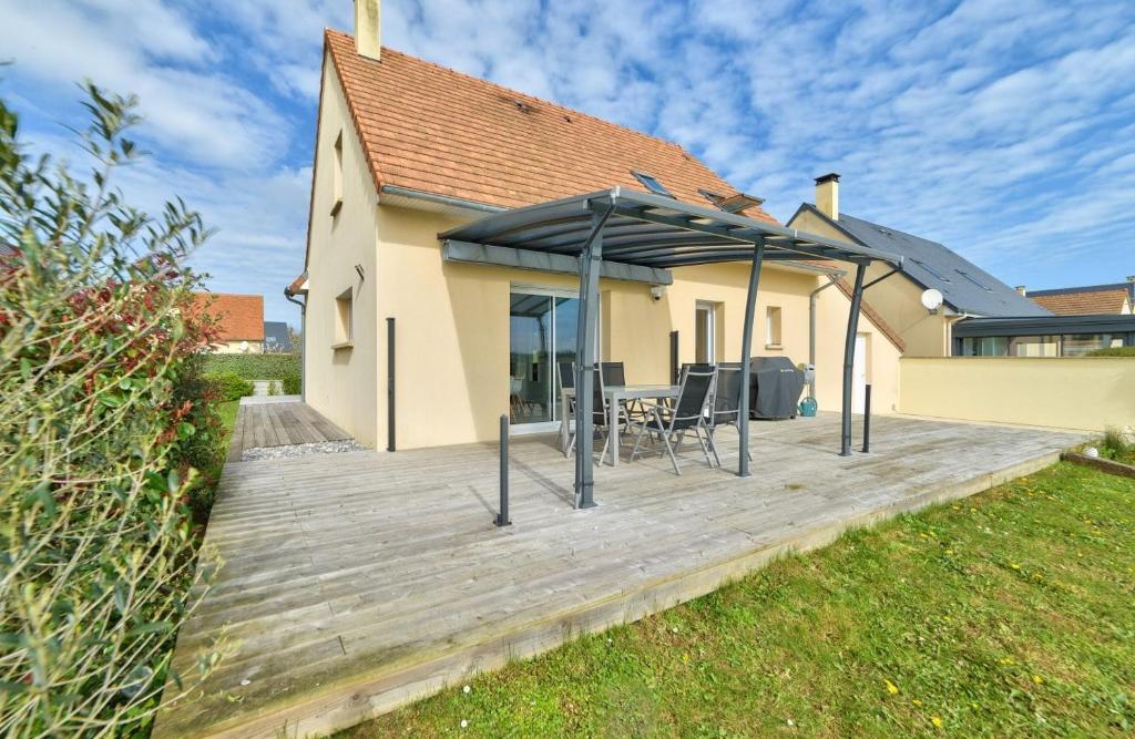 une terrasse en bois avec un kiosque en face d'une maison dans l'établissement Maison Flair, à Varaville