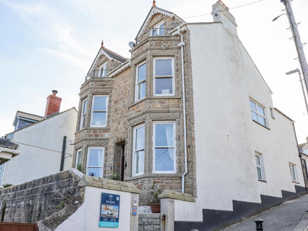 an old brick house with a steep staircase in front of it at Whistler in St Ives