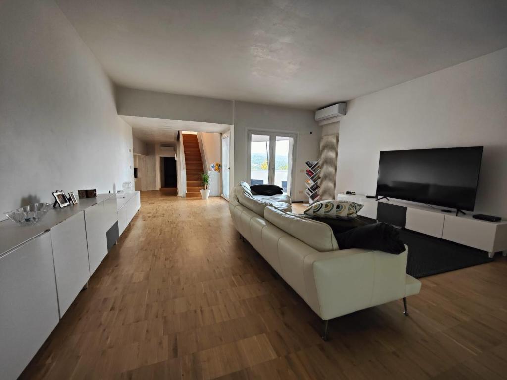 a living room with a white couch and a flat screen tv at Nuovo Progetto A&E in Vicenza