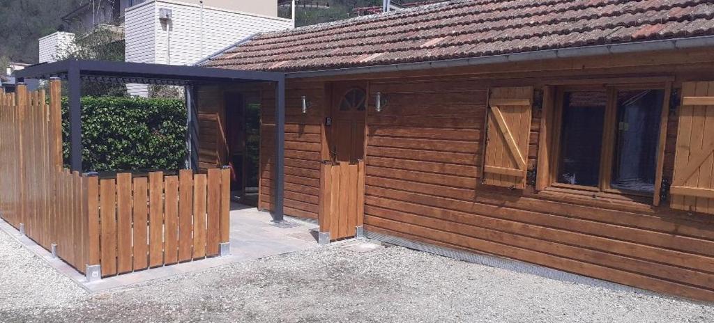 une cabane en bois avec une clôture et une porte dans l'établissement Paquito, mini maison 1 chambre avec terrasse et parking, à Ax-les-Thermes