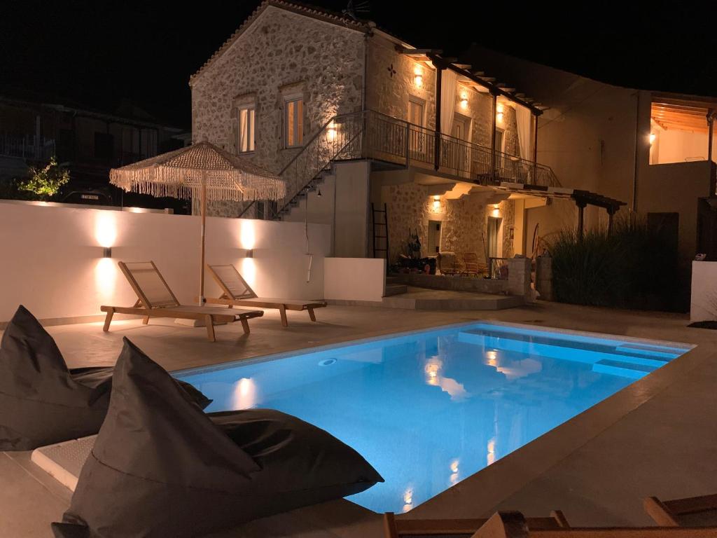 a swimming pool in front of a house at night at mangata suite home private pool in Spartokhórion