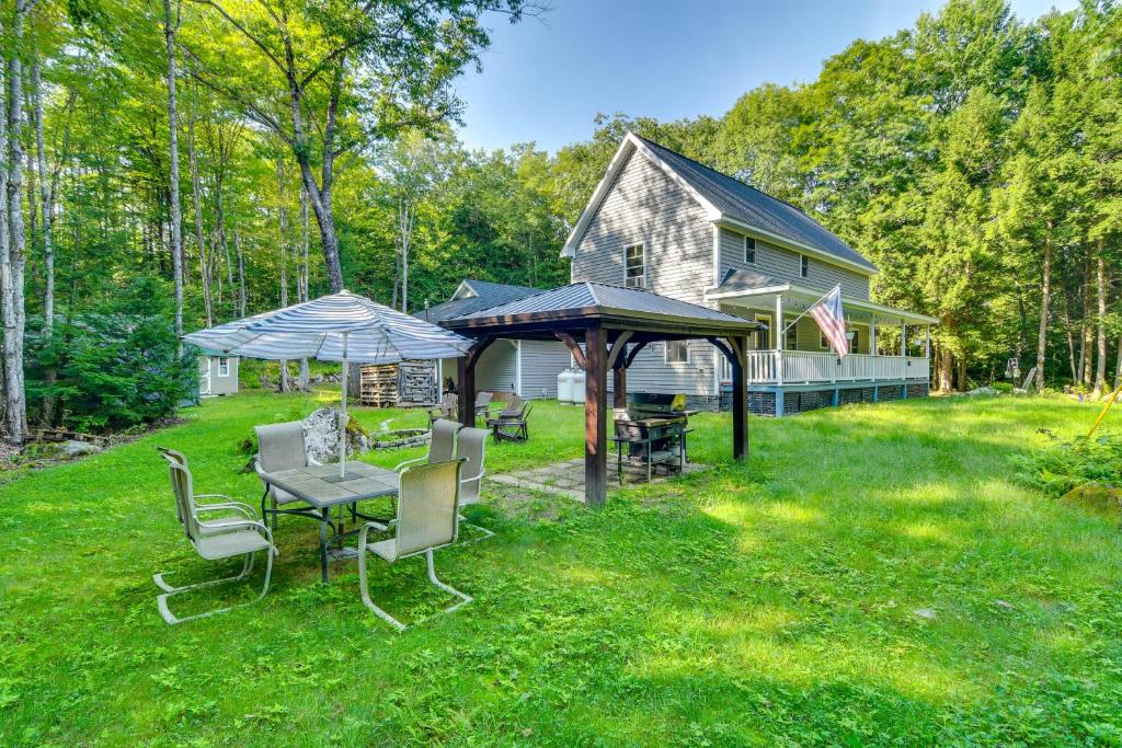 a yard with a table and chairs and a house at The Locke-ness Pond Cabin in Chesterville! in Wilton