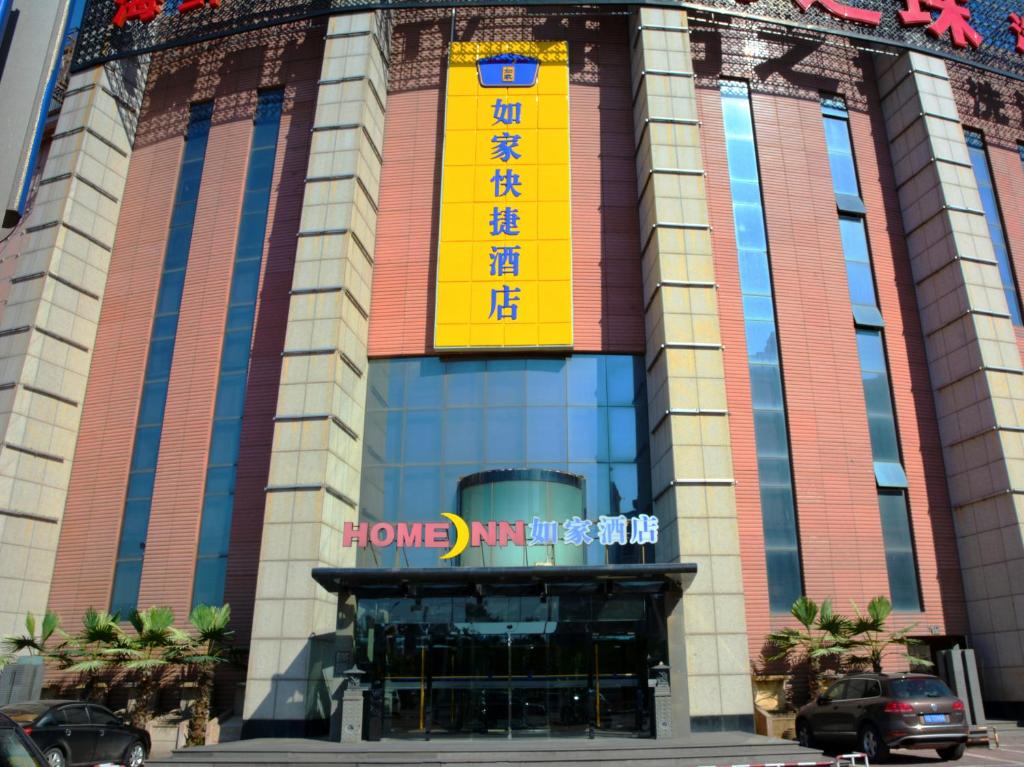 a building with a yellow sign on the front of it at Home Inn Tianjin Wuqing Jingjin Road in Wuqing