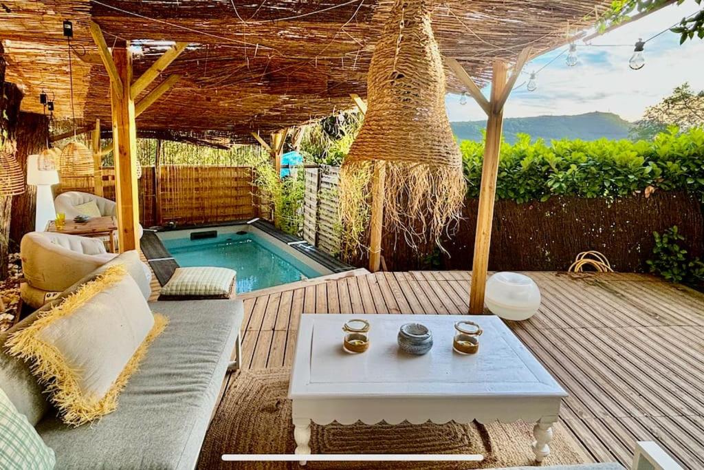 une terrasse avec un canapé, une table et une piscine dans l'établissement Jolie maison en pleine nature, à Tourrettes-sur-Loup