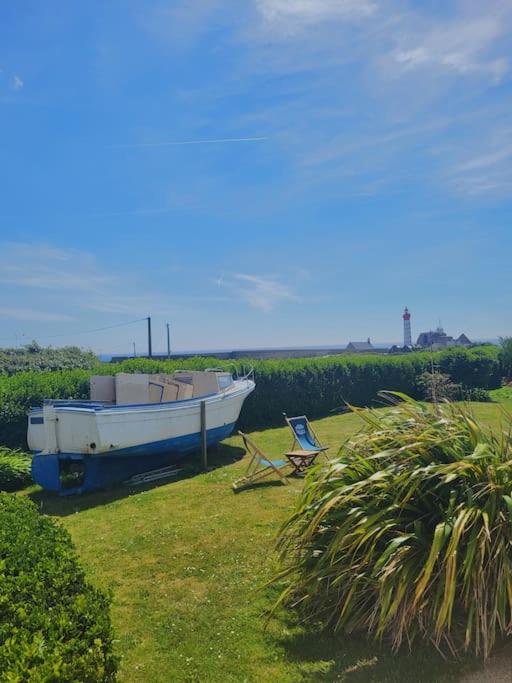 un bateau et une chaise sur l'herbe dans l'établissement Le repère de Saint Mathieu, à Plougonvelin