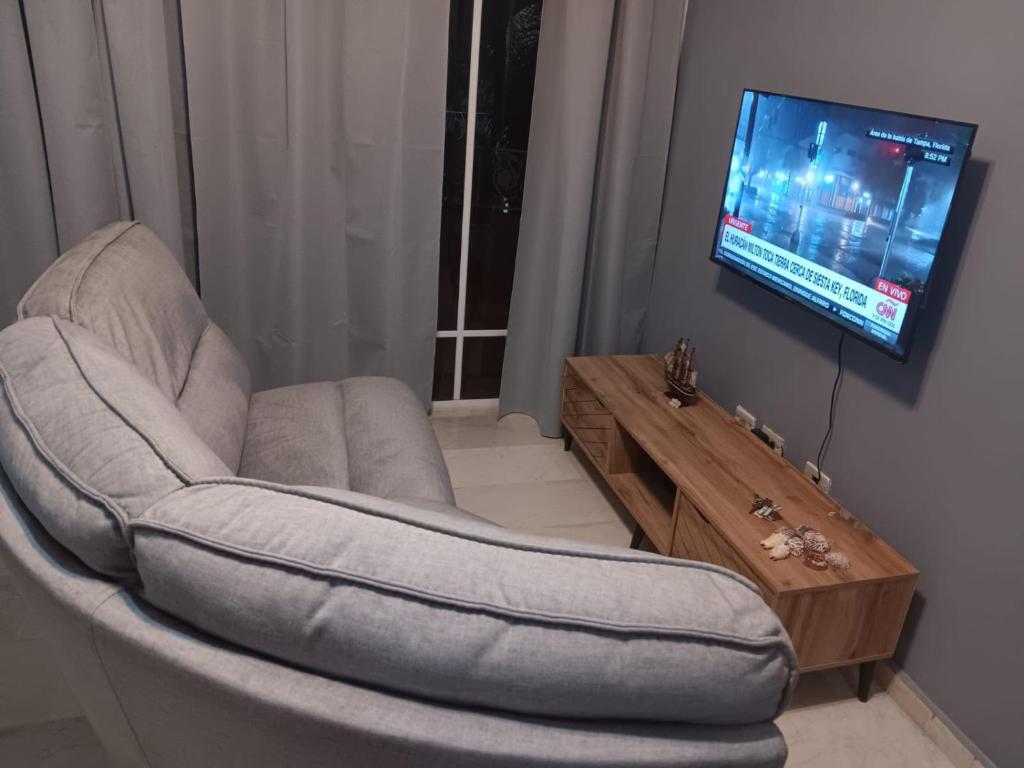 sala de estar con silla y TV de pantalla plana en Juan Dolio,Beach, Pool, 40"TV , Optic Internet, Relax, en Villas del Mar
