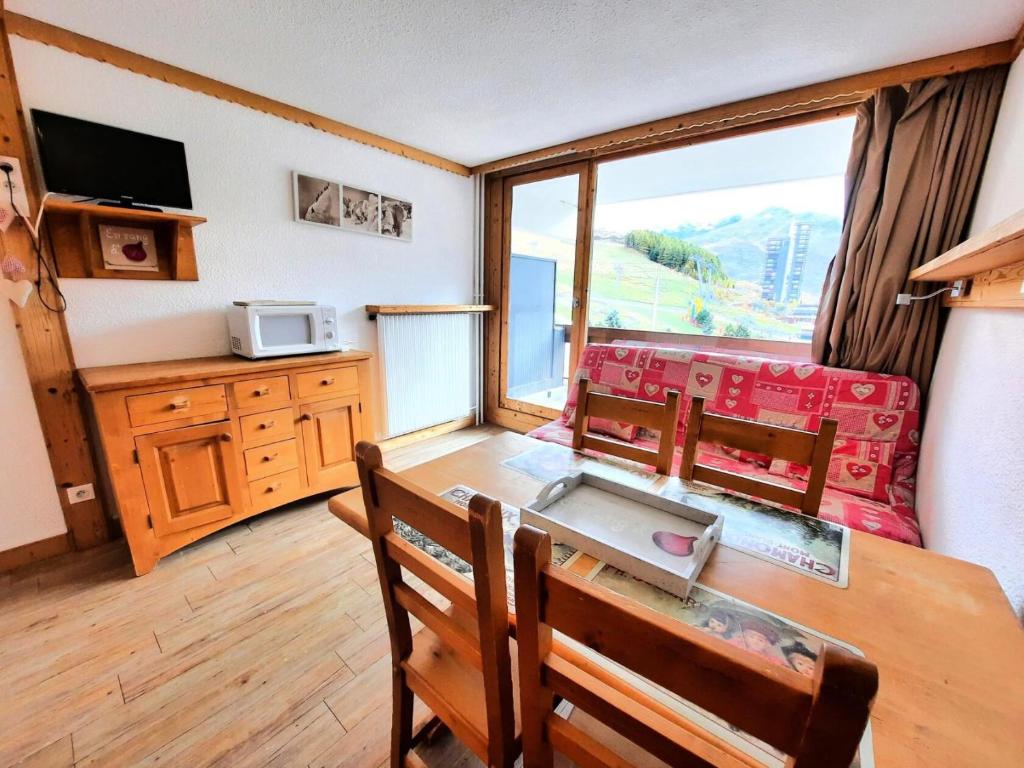 une salle à manger avec une table et des chaises et une fenêtre dans l'établissement Résidence Chaviere - Studio ski aux pieds au coeur des Ménuires MAE-4114, aux Menuires