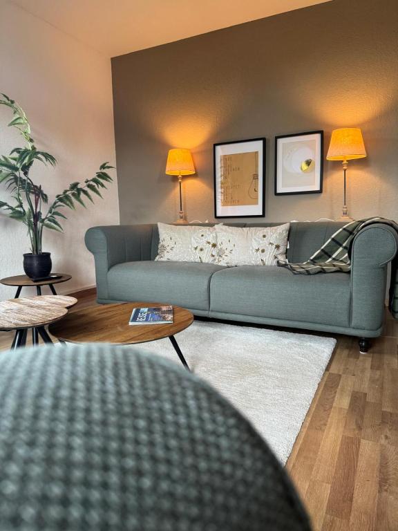 a living room with a blue couch and two lamps at Ferienwohnung Uranus 1A in Annaberg-Buchholz