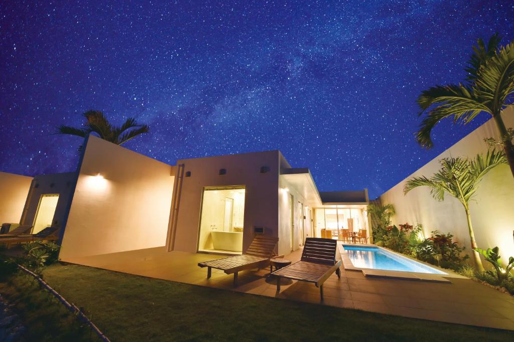 a house with a swimming pool at night at Feliz Villa Suite Miyakojima Ueno in Miyako Island