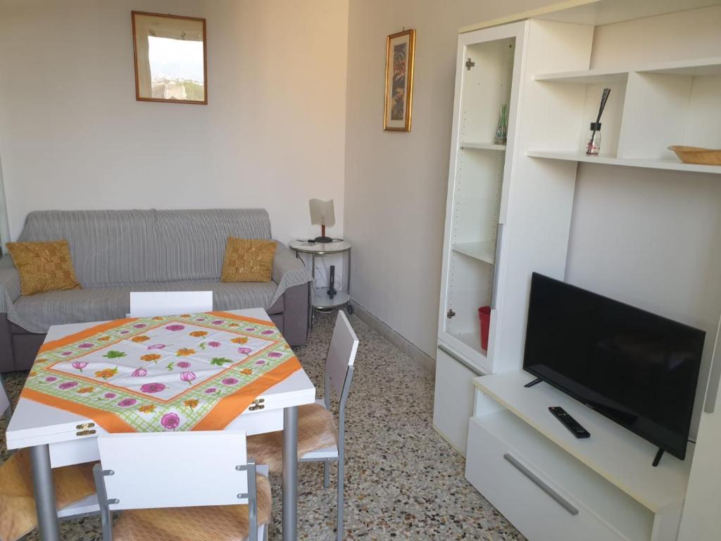 a small living room with a table and a tv at Risorgimento House in Catania