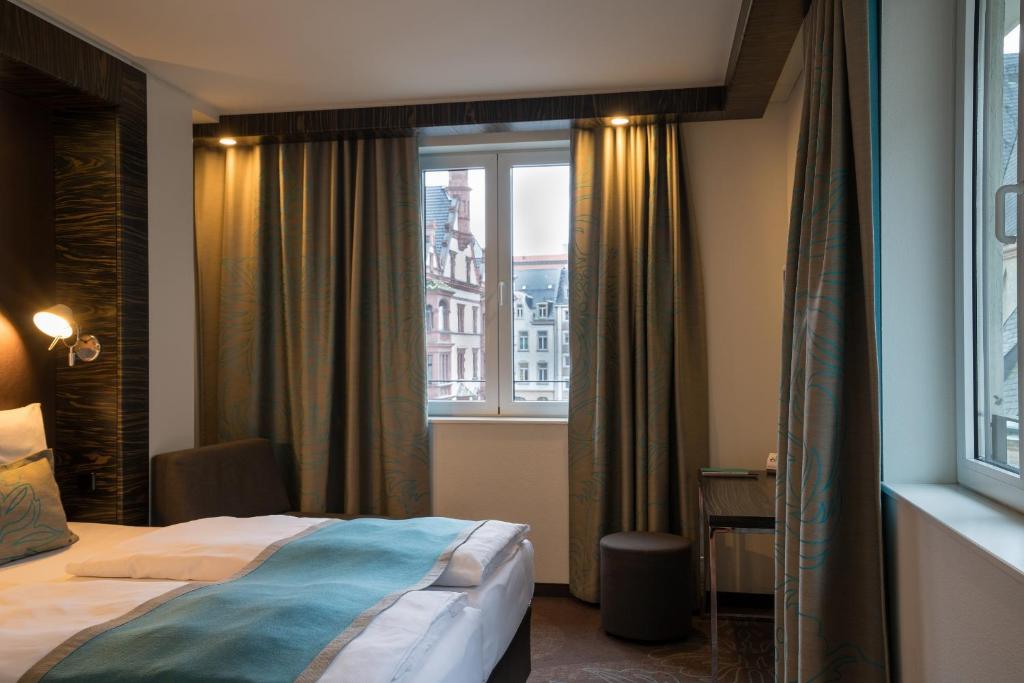 Postel nebo postele na pokoji v ubytování Motel One Leipzig-Nikolaikirche