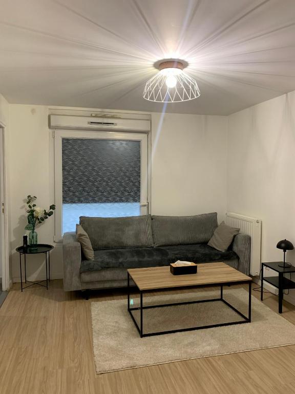 un salon avec un canapé et une table basse dans l'établissement Chambre privée Sdb kitchenette proche de Paris, à Saint-Ouen