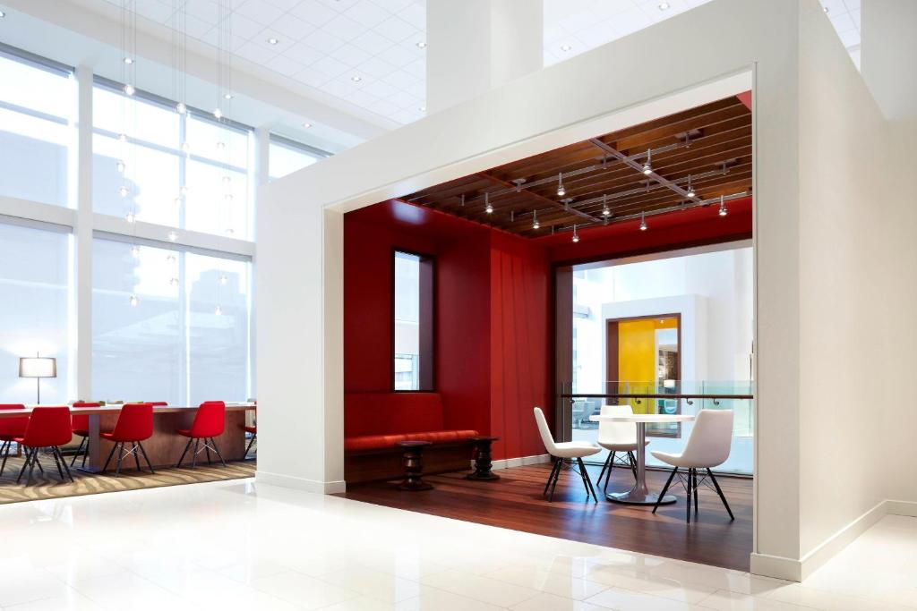 a dining room with red chairs and a table at Delta Hotels by Marriott Ottawa City Centre in Ottawa