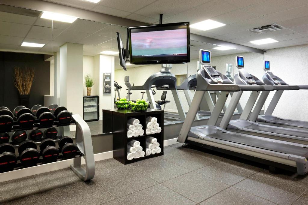 a gym with a treadmill and a flat screen tv at Delta Hotels by Marriott Ottawa City Centre in Ottawa