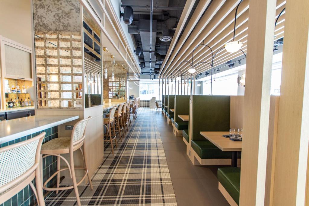 a dining room with green chairs and tables at Delta Hotels by Marriott Ottawa City Centre in Ottawa