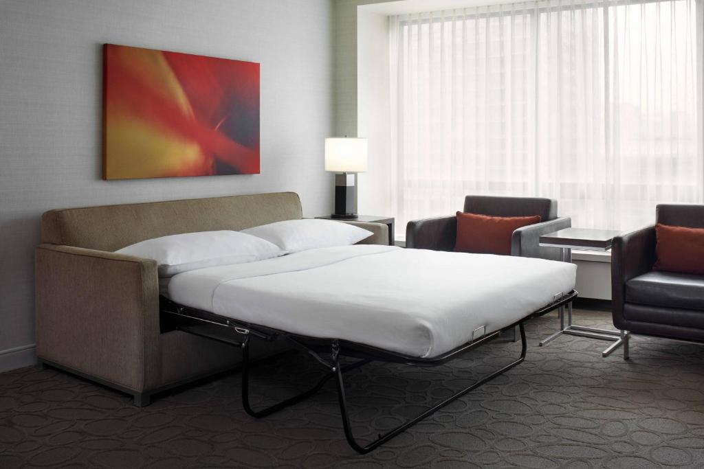 a hospital room with a bed and a chair at Delta Hotels by Marriott Ottawa City Centre in Ottawa