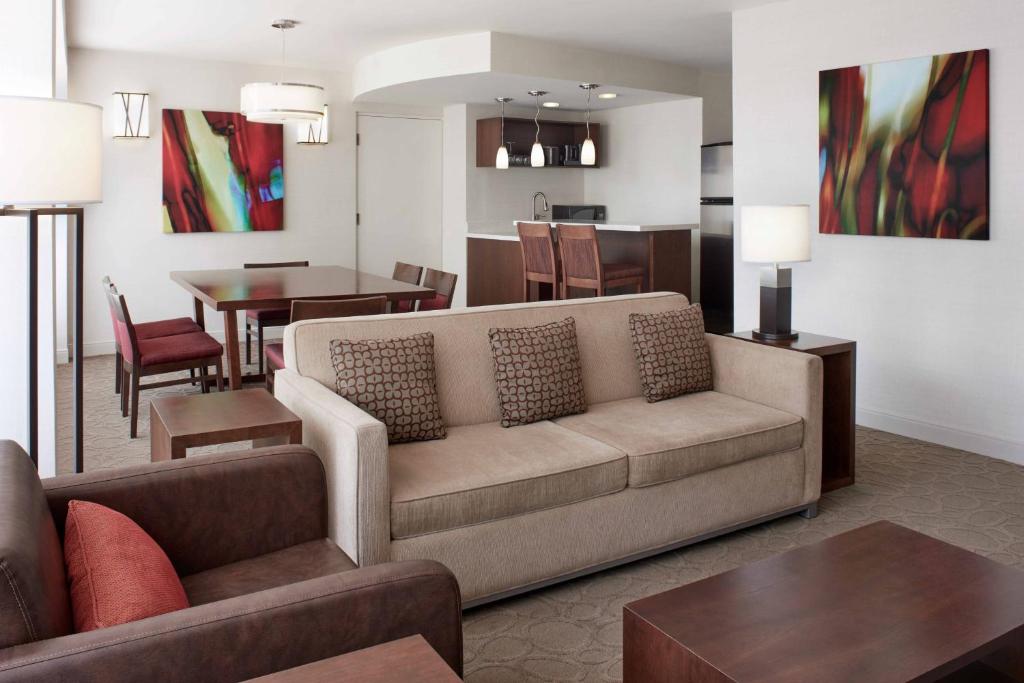 a living room with a couch and a dining room at Delta Hotels by Marriott Ottawa City Centre in Ottawa