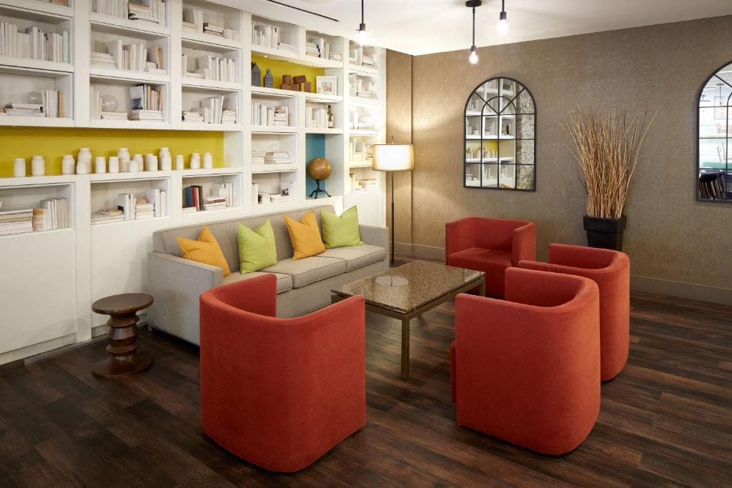 a living room with orange chairs and a couch at Delta Hotels by Marriott Ottawa City Centre in Ottawa