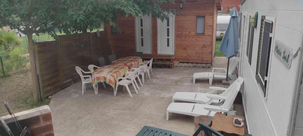 un patio avec des tables et des chaises et un bâtiment dans l'établissement Vacances en bord de mer, au Grau-dʼAgde