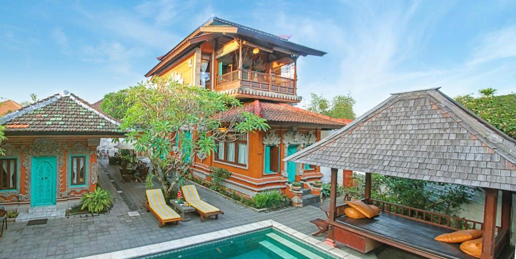 una casa con piscina frente a una casa en Sunhouse Guesthouse, en Sanur