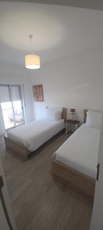 ein Schlafzimmer mit zwei Betten und einem Fenster in der Unterkunft BeachCity Guesthouse in Lagos