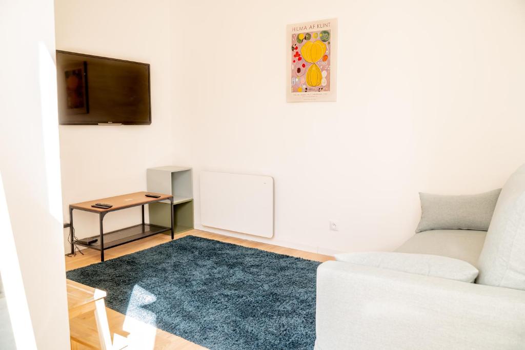 un salon avec un canapé et une table dans l'établissement L'atelier de la Placette YourHostHelper, à Nîmes