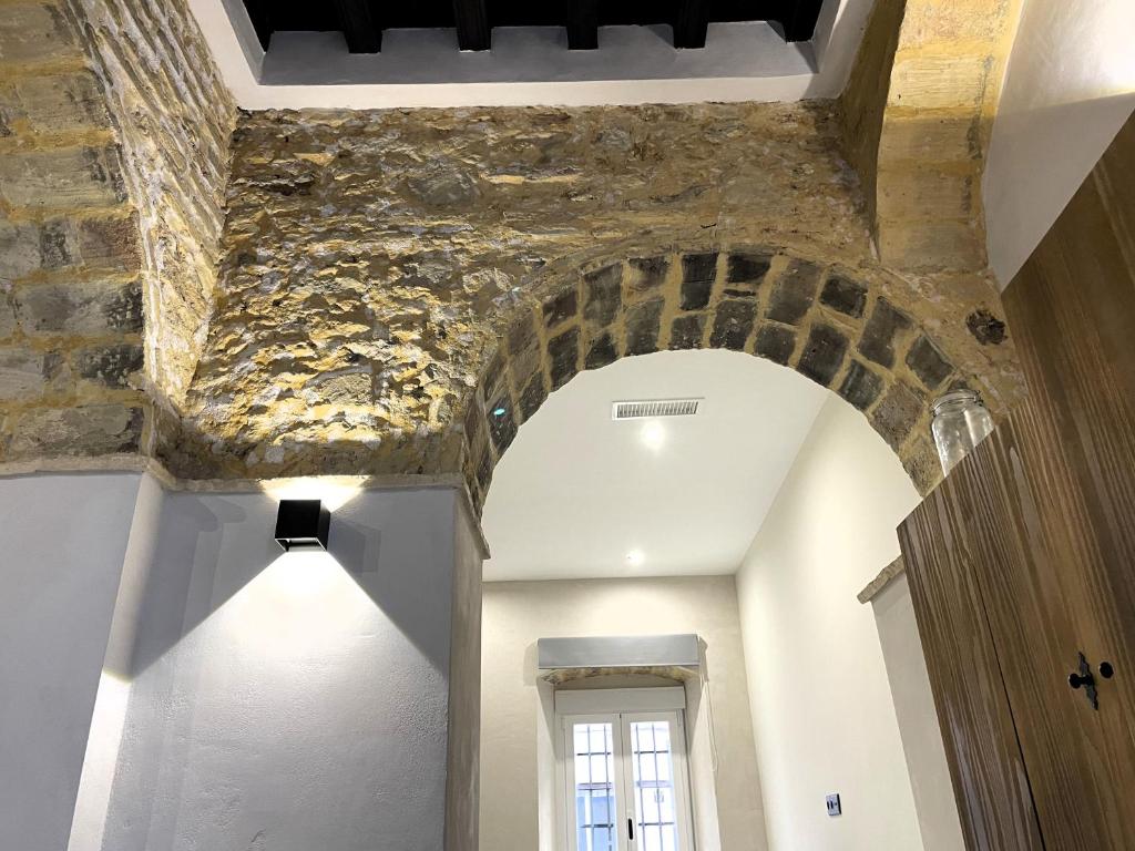an archway in a room with a stone wall at Apartamento Plaza del Cabildo II - Sanlúcar Centro in Sanlúcar de Barrameda