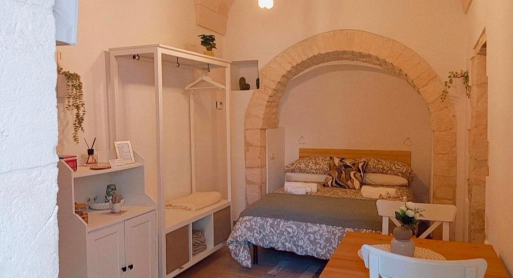 une chambre avec un lit et une table dedans dans l'établissement La Casetta di Francy, à Martina Franca