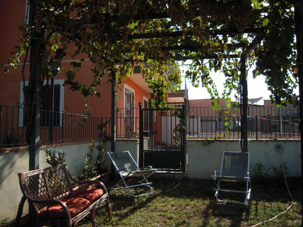 a patio with chairs and a pergola in a yard at Casa Malù in SantʼAlfio