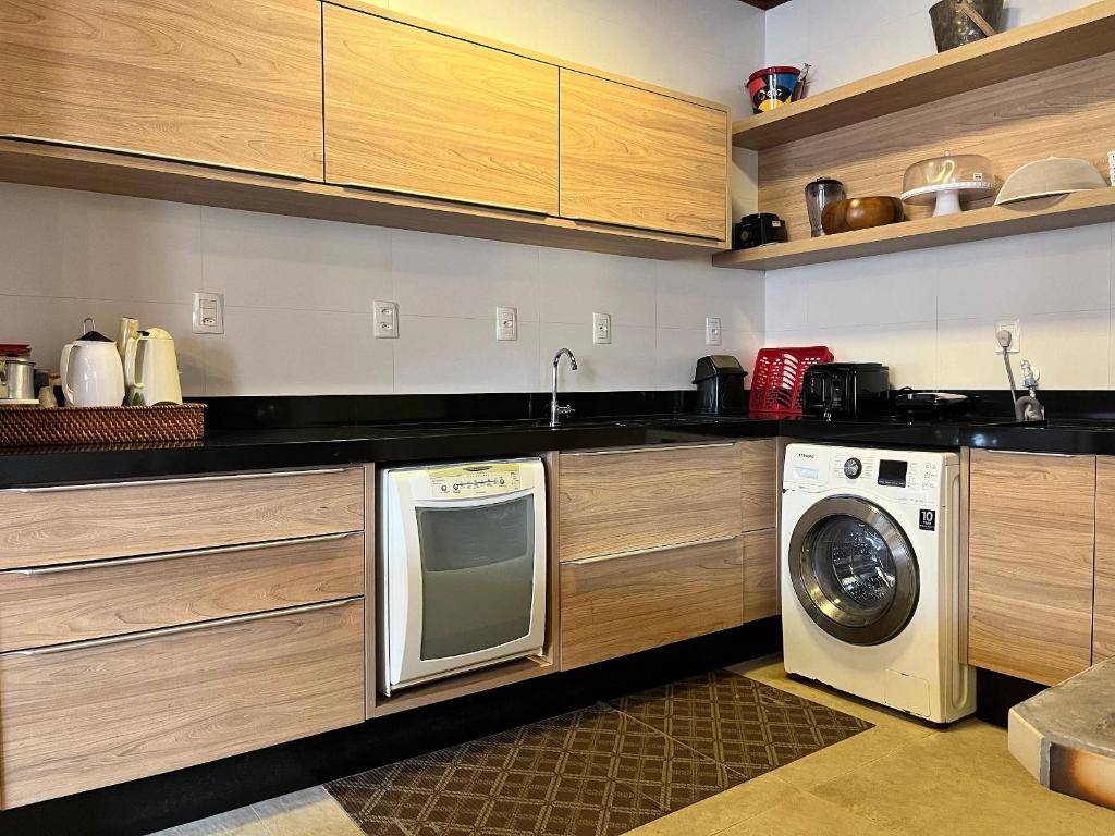 邦比尼亚斯B167 - Casa de Alto Padrão com Piscina Privativa e Espaço Gourmet a 450m do Mar na Praia de Mariscal - Bombinhas-SC的厨房配有洗衣机和洗衣机。