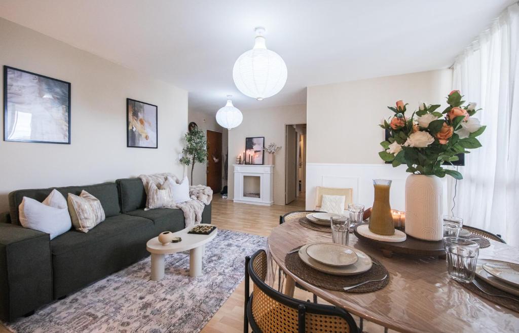 ein Wohnzimmer mit Sofa und Tisch in der Unterkunft Appartement avec Rétroprojecteur, Babyboot avec belle vue et proche gare in Saint-Pierre-des-Corps