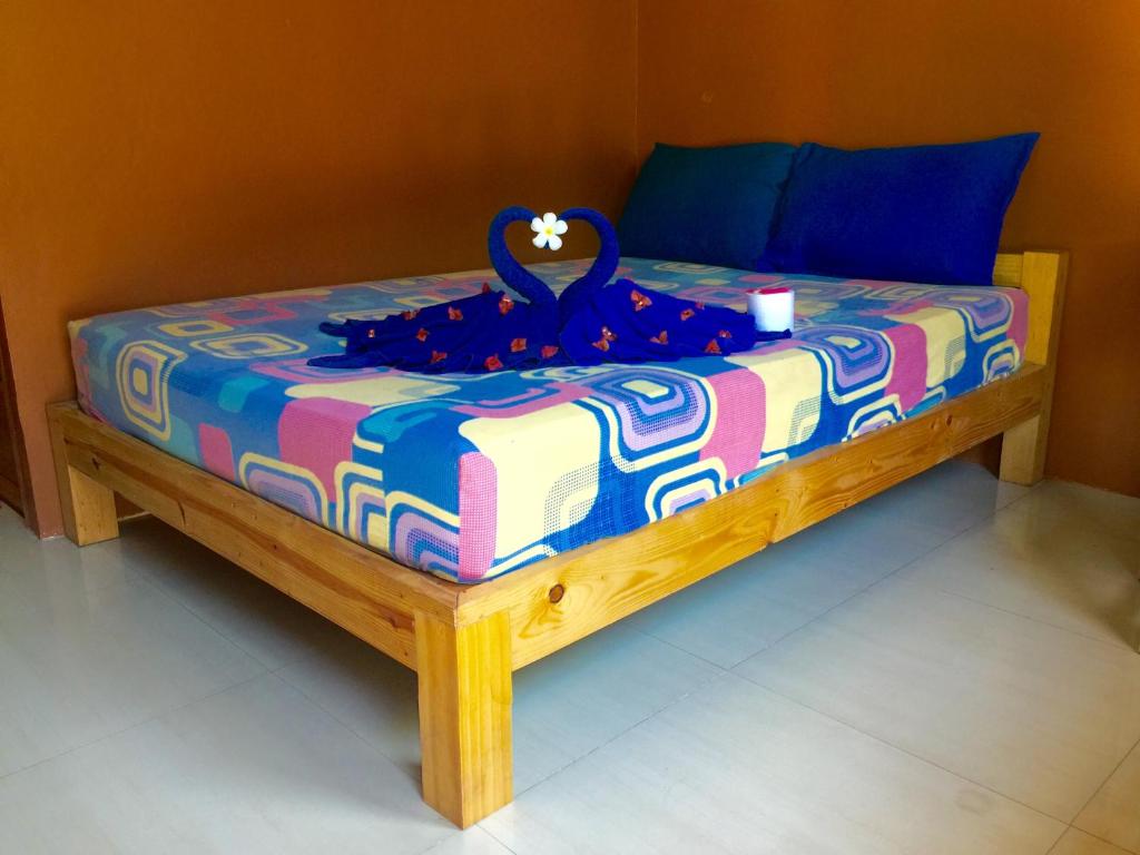 a bed with a blue and colorful blanket on it at Miss Tim House in Ko Samed