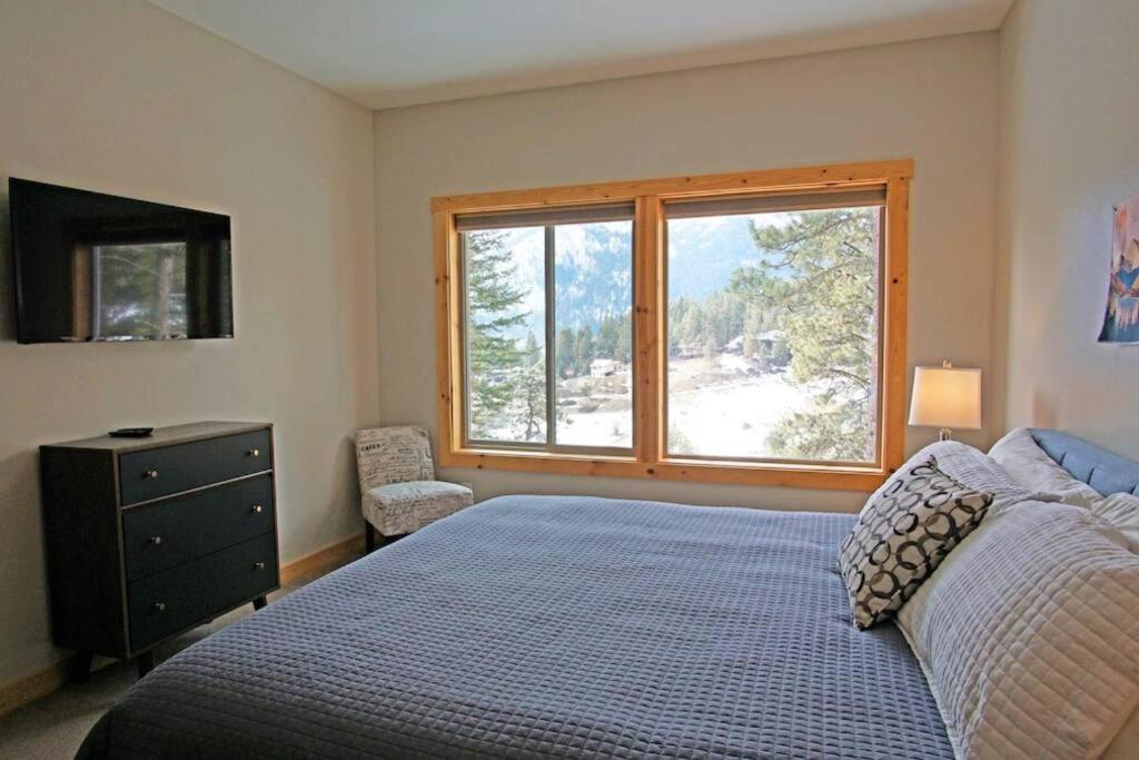 a bedroom with a bed and a large window at Alpine Lodge - Epic Mountain Views, Hot Tub, 2 Miles to Town in Leavenworth
