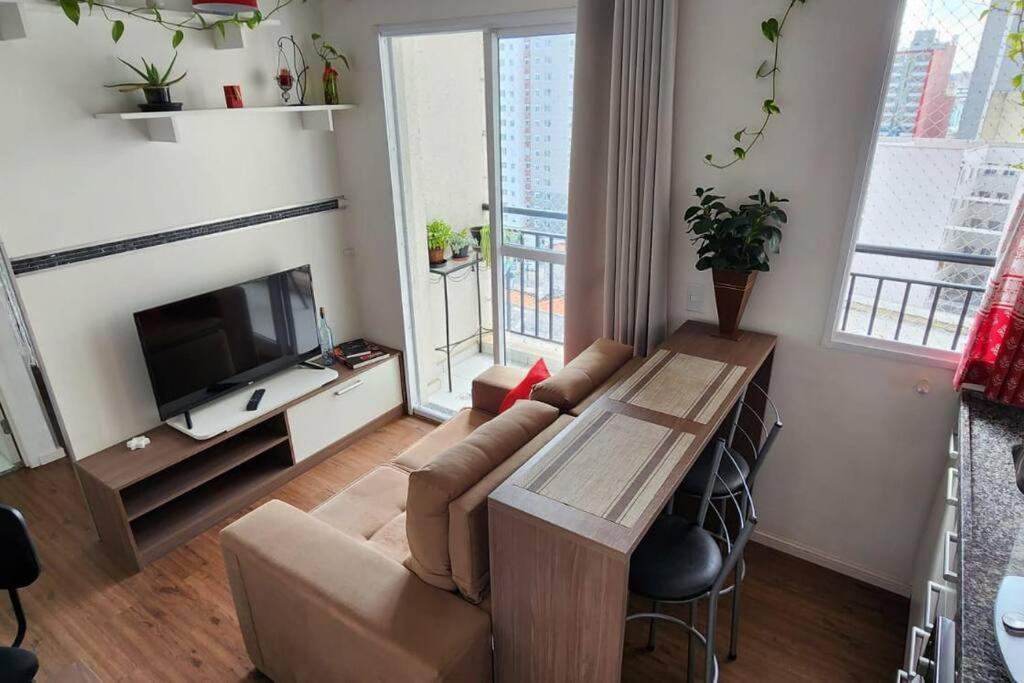 a living room with a couch and a table at AP BOHO 1010 Brás - Piscina Aquecida, WiFi, Academia, Cama Casal box e colchão extra solteiro in Sao Paulo