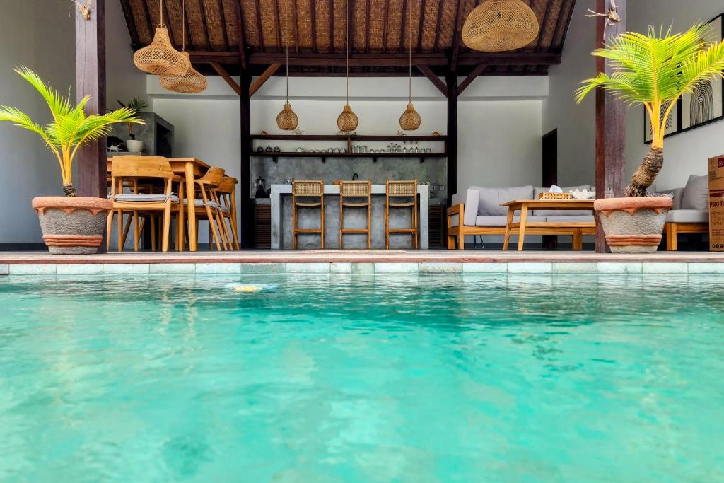 a swimming pool in a resort with a table and chairs at Villa Diamond Lembongan in Nusa Lembongan