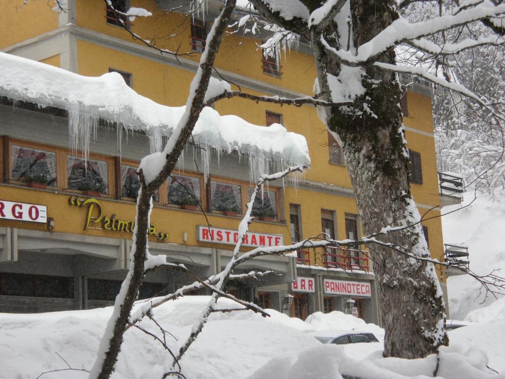 ein Gebäude mit Eiszapfen im Schnee in der Unterkunft Hotel Primula in Abetone