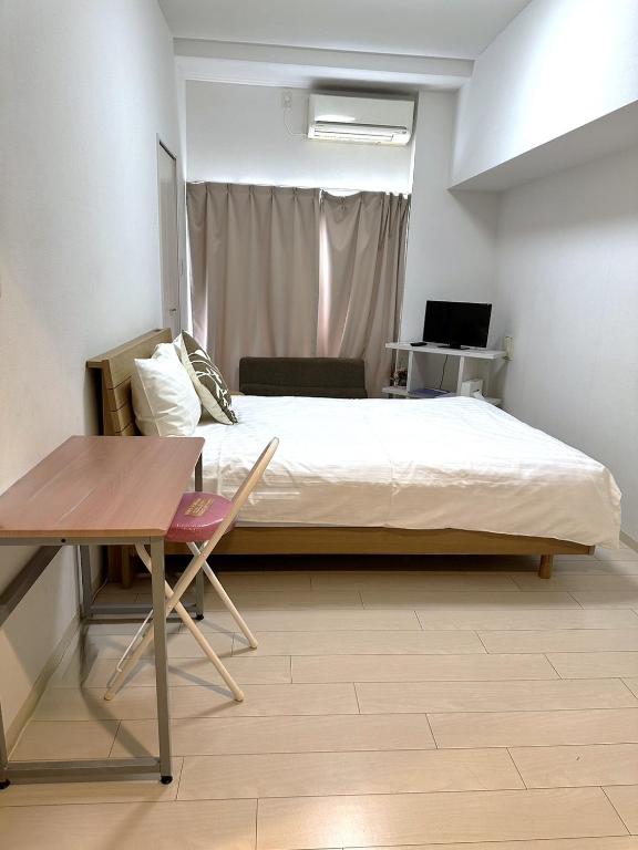 Postel nebo postele na pokoji v ubytování Residence天王寺東
